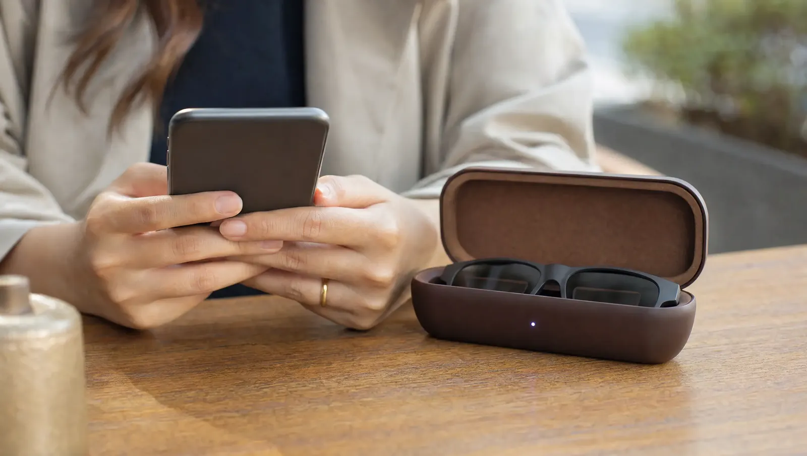 Frau koppelt ihre Smartbrille im Ladeetui mit dem Smartphone