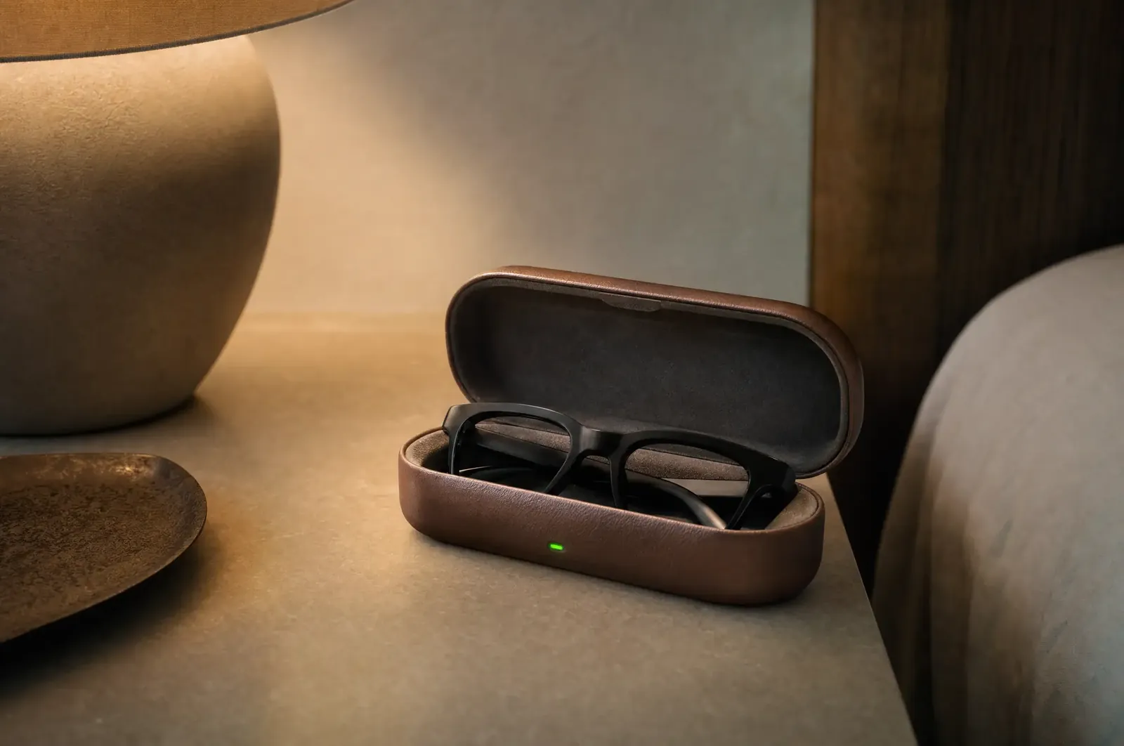 Smartbrille lädt im geöffneten Ladeetui auf dem Nachttisch